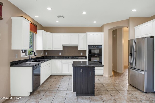 kitchen featuring white cabinets, sink, a kitchen island, and black appliances