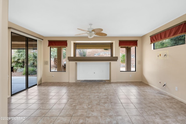 unfurnished living room with a wealth of natural light, ceiling fan, and light tile patterned floors