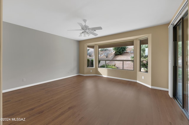 unfurnished room with ceiling fan and dark hardwood / wood-style flooring