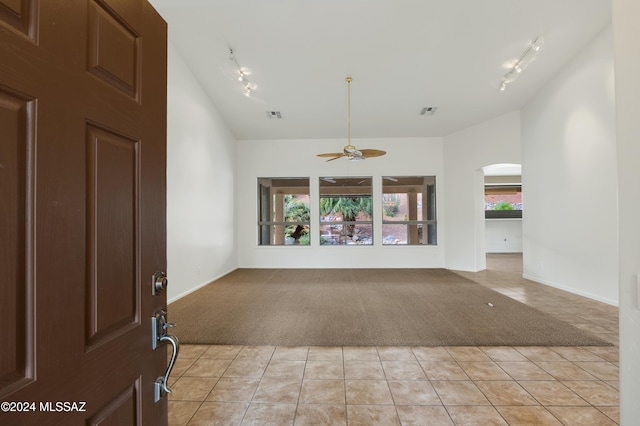 interior space with ceiling fan, light tile patterned flooring, a healthy amount of sunlight, and track lighting