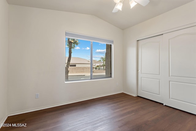 unfurnished bedroom with dark hardwood / wood-style flooring, a closet, lofted ceiling, and ceiling fan