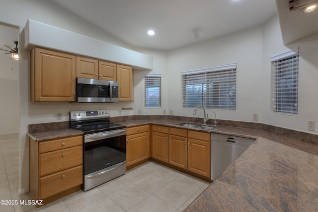 kitchen featuring vaulted ceiling, sink, light tile patterned floors, ceiling fan, and stainless steel appliances