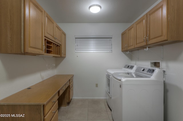 laundry room featuring cabinets, light tile patterned flooring, and separate washer and dryer