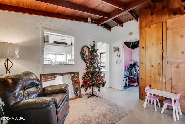 living area with lofted ceiling with beams, concrete floors, and wooden ceiling