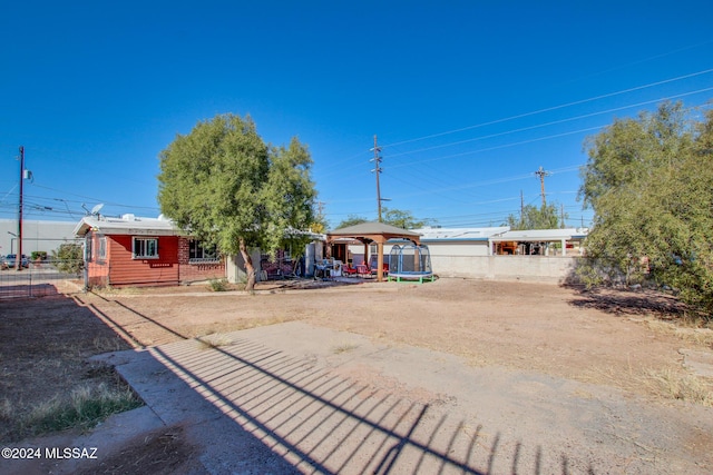 ranch-style house with a gazebo and a trampoline