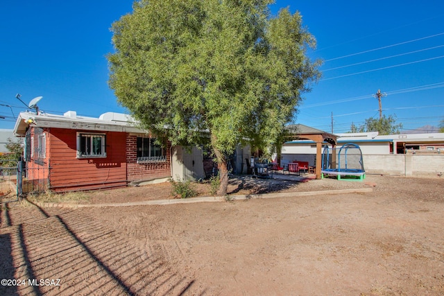 ranch-style home with a gazebo and a trampoline