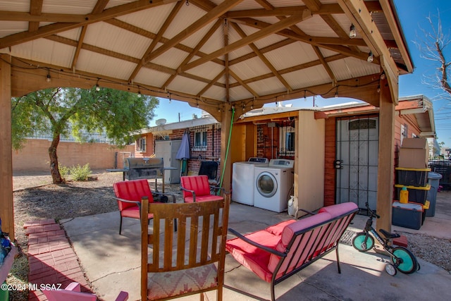 view of patio / terrace with a gazebo, independent washer and dryer, and a grill