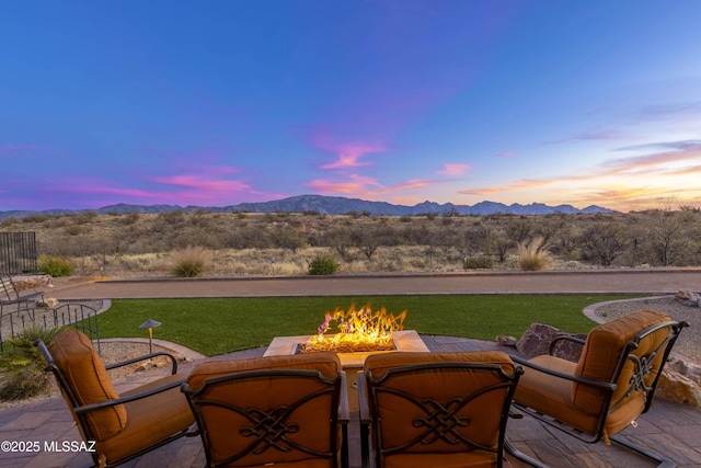 view of patio / terrace featuring an outdoor fire pit and a mountain view