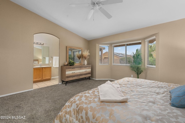 carpeted bedroom with connected bathroom, ceiling fan, and lofted ceiling