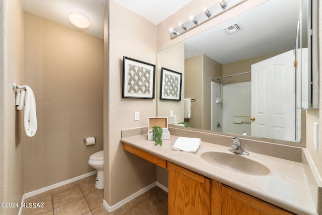 bathroom with tile patterned flooring, vanity, toilet, and a shower