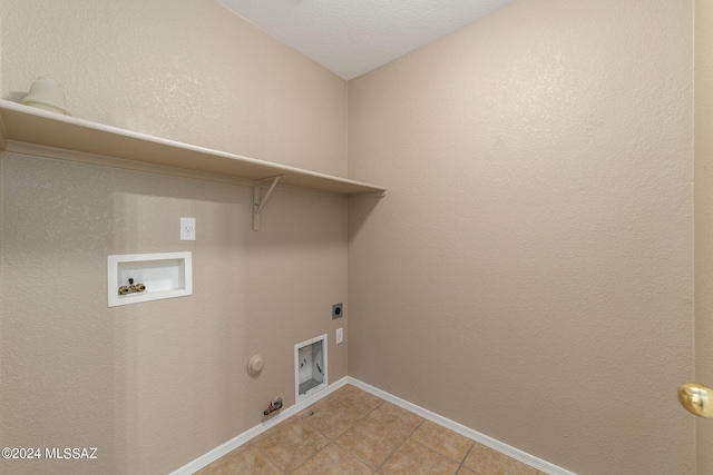 washroom with hookup for a gas dryer, hookup for a washing machine, light tile patterned floors, a textured ceiling, and hookup for an electric dryer