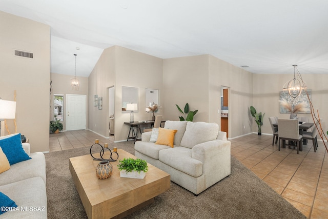 living room with tile patterned floors, a towering ceiling, and an inviting chandelier