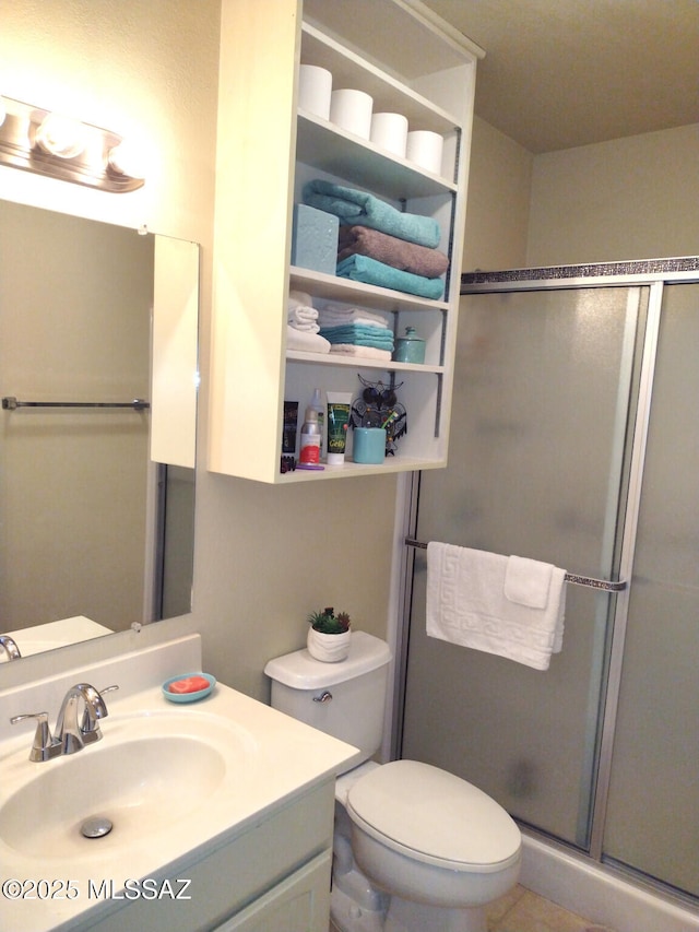 bathroom with toilet, vanity, and walk in shower