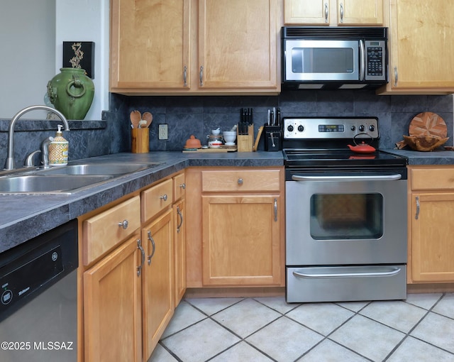 kitchen with light tile patterned floors, stainless steel appliances, sink, and backsplash