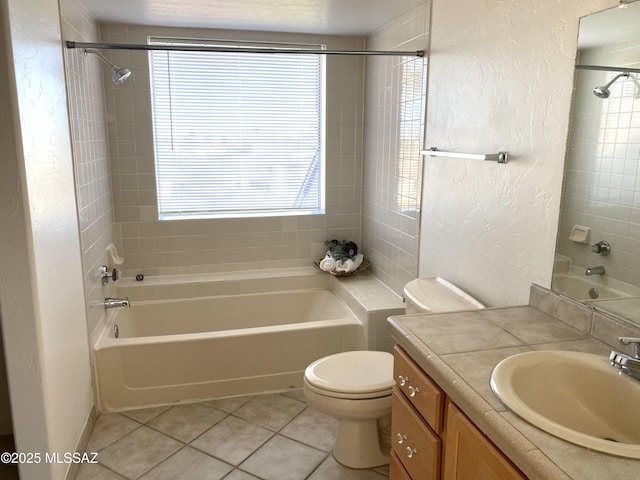 full bath with a textured wall, toilet, bathing tub / shower combination, tile patterned flooring, and vanity