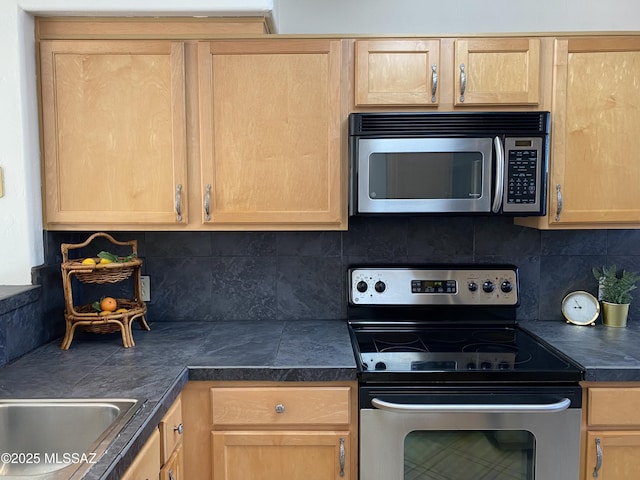 kitchen featuring stainless steel appliances, tasteful backsplash, and light brown cabinets