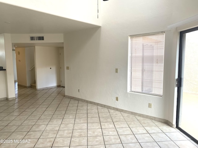 5675 N Camino Esplendora Unit 5228, Tucson, AZ 85718 - spare room featuring light tile patterned floors, stairway, and baseboards