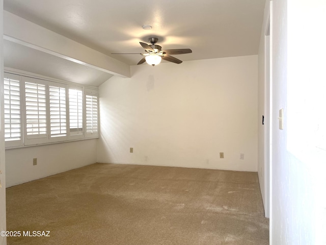 spare room featuring carpet flooring, vaulted ceiling with beams, and ceiling fan