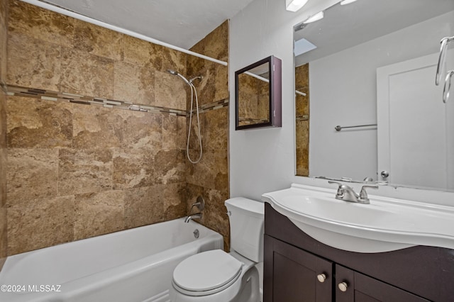 full bathroom featuring vanity, tiled shower / bath combo, and toilet