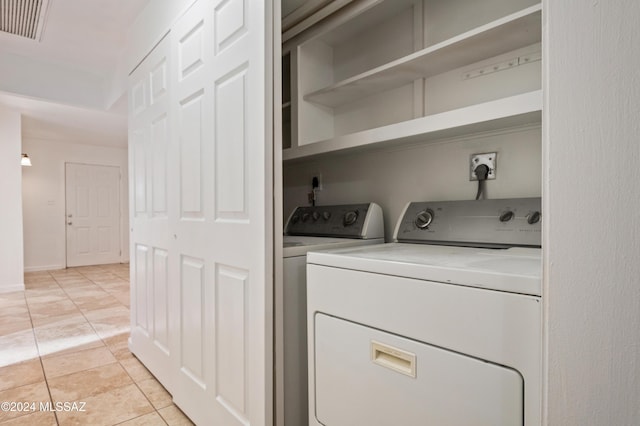 laundry area featuring washer and clothes dryer and light tile patterned flooring