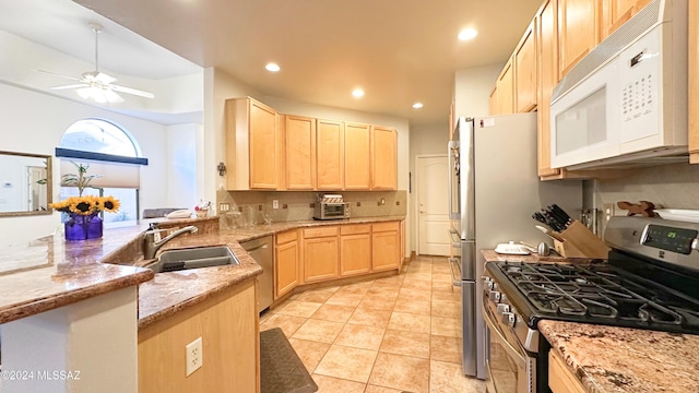 kitchen with appliances with stainless steel finishes, light stone counters, ceiling fan, sink, and light brown cabinets