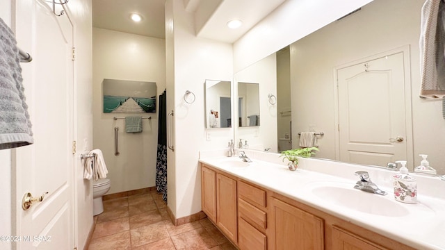 bathroom with tile patterned flooring, vanity, and toilet