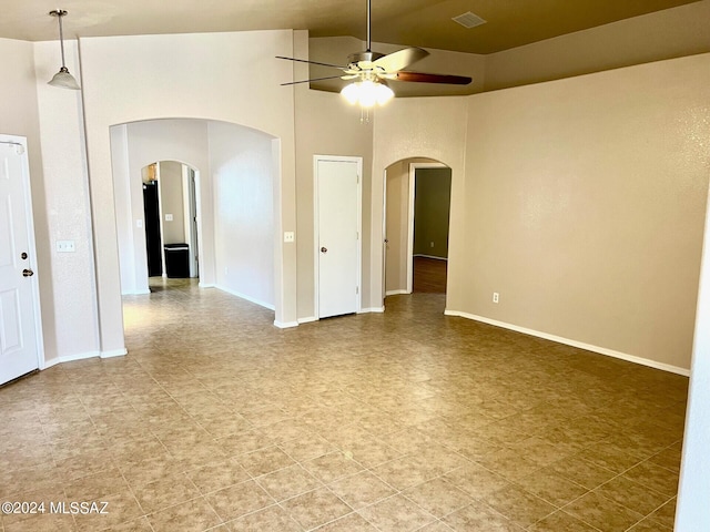 empty room with high vaulted ceiling and ceiling fan