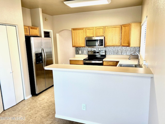 kitchen with backsplash, sink, kitchen peninsula, and stainless steel appliances