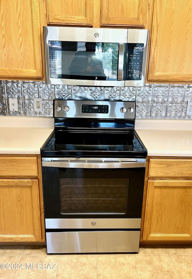 kitchen with light tile patterned floors and stainless steel appliances