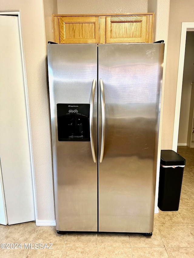 kitchen featuring light brown cabinets, light tile patterned floors, and stainless steel refrigerator with ice dispenser