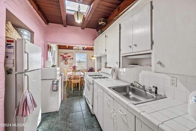 kitchen featuring white appliances, tile countertops, wood ceiling, and sink