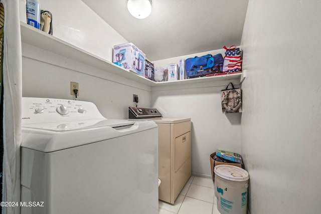 laundry room with independent washer and dryer and light tile patterned floors