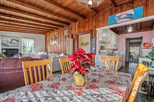 dining space with wood walls, beamed ceiling, and wooden ceiling