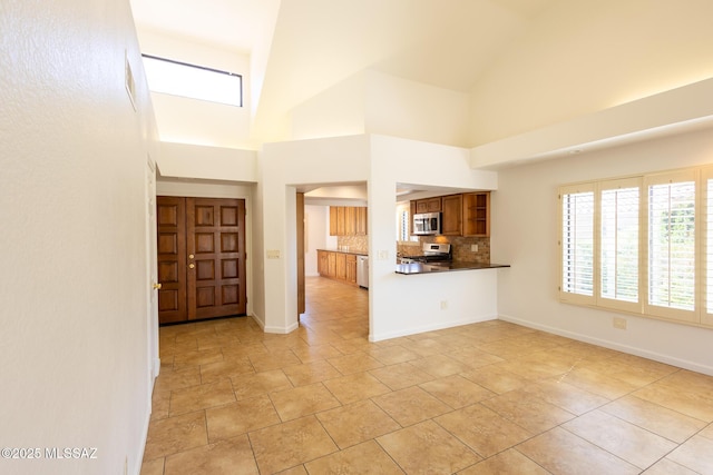 entrance foyer featuring baseboards and a towering ceiling