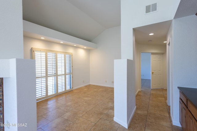 unfurnished room with visible vents, baseboards, vaulted ceiling, light tile patterned floors, and recessed lighting