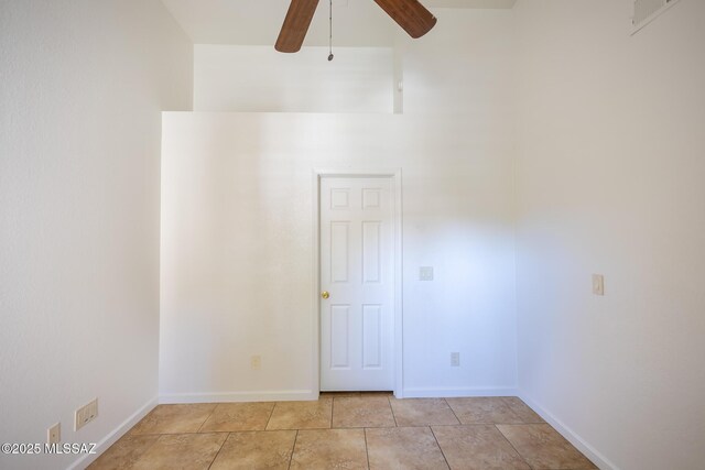 unfurnished bedroom with light tile patterned floors, baseboards, lofted ceiling, and a ceiling fan