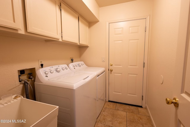 washroom with washer and clothes dryer, sink, light tile patterned flooring, and cabinets