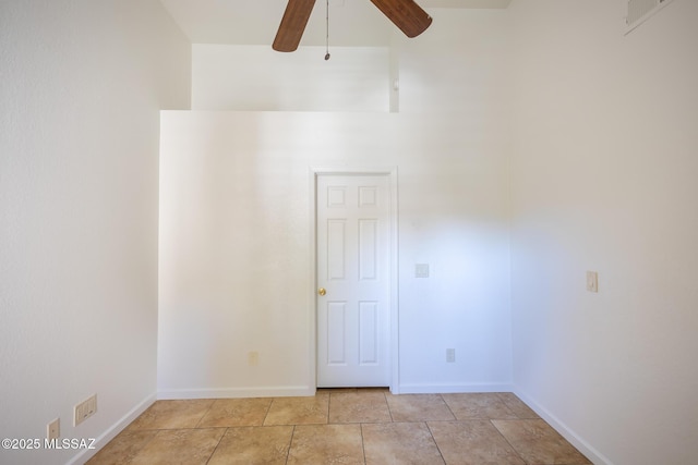 unfurnished room with baseboards, ceiling fan, and light tile patterned flooring