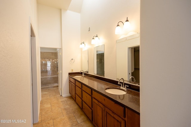 full bathroom with a sink, walk in shower, and double vanity