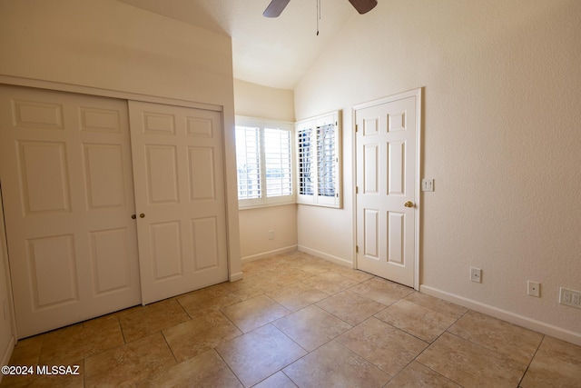 unfurnished bedroom featuring ceiling fan, light tile patterned floors, and vaulted ceiling