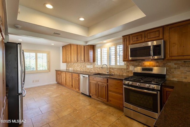 kitchen featuring tasteful backsplash, plenty of natural light, appliances with stainless steel finishes, and a sink