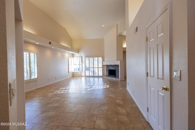 unfurnished living room with a wealth of natural light, light tile patterned floors, and lofted ceiling