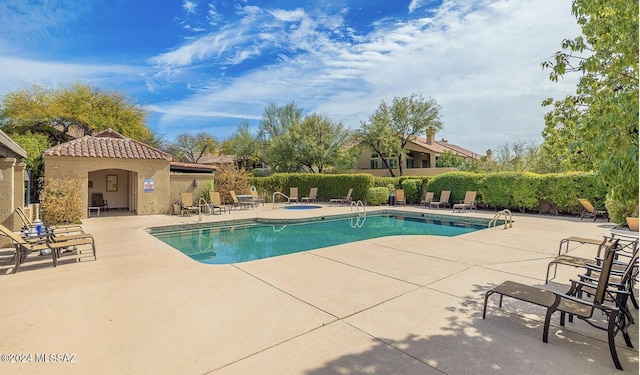 view of pool with a community hot tub and a patio area