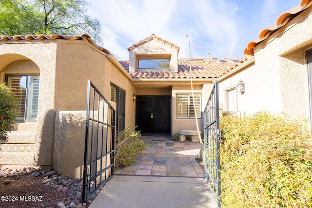 entrance to property with stucco siding and a tile roof