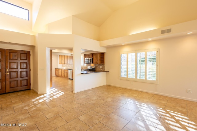 unfurnished living room with high vaulted ceiling