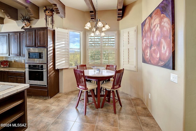 dining space with beamed ceiling, a chandelier, and light tile patterned flooring