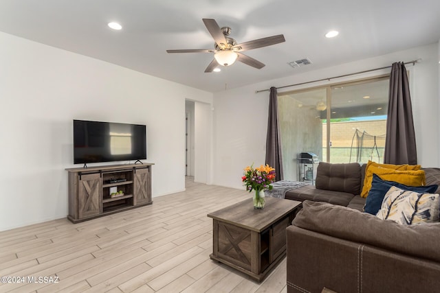 living room featuring light wood-style flooring, visible vents, a ceiling fan, and recessed lighting