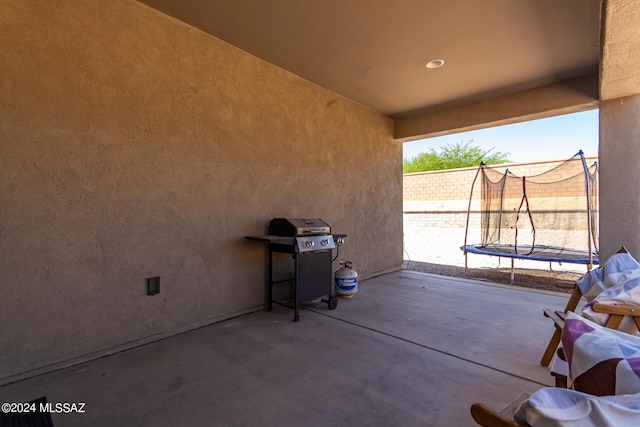 view of patio with area for grilling and a trampoline