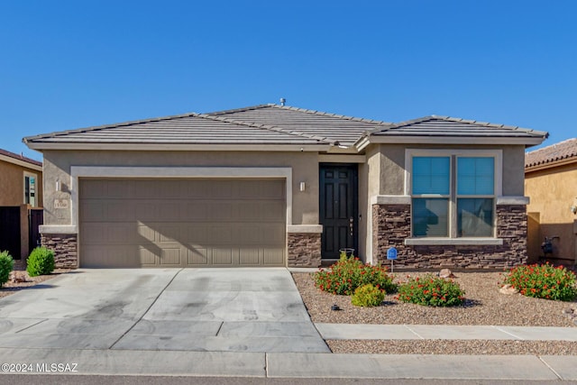 view of front of house featuring stucco siding, concrete driveway, an attached garage, stone siding, and a tiled roof