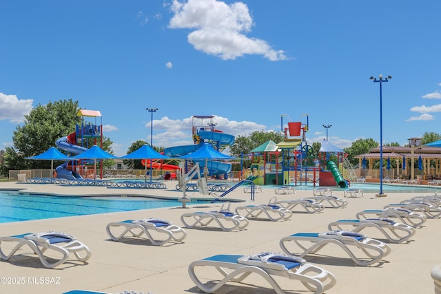 pool with playground community, a water play area, and a water slide